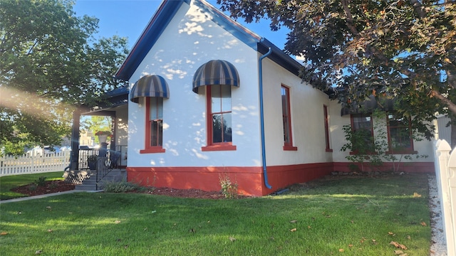 view of side of home with a yard