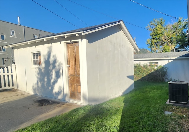 view of home's exterior featuring a yard, central AC, and an outbuilding