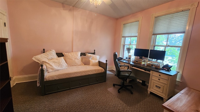 home office with a textured ceiling and dark carpet