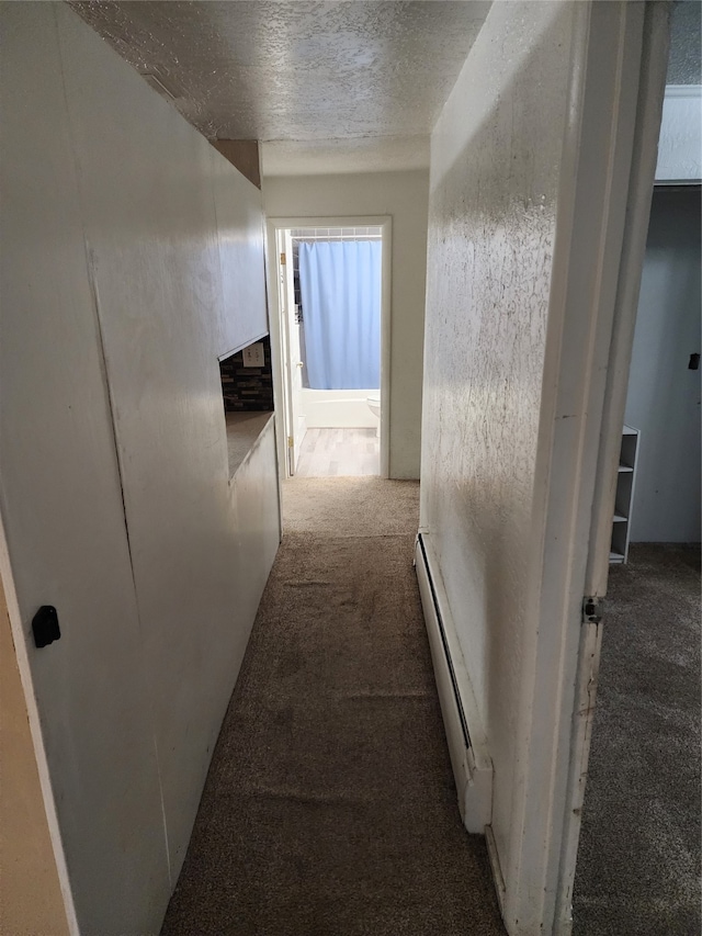 hall with a baseboard heating unit, a textured ceiling, and carpet floors