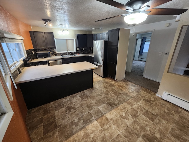 kitchen with decorative backsplash, ceiling fan, a textured ceiling, sink, and stainless steel appliances