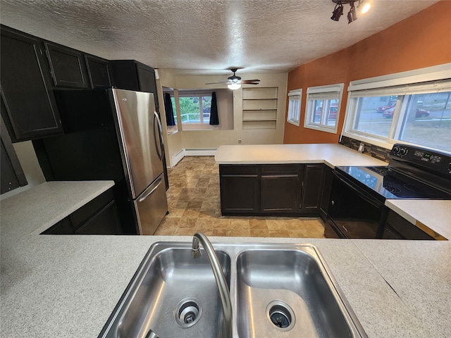 kitchen with ceiling fan, a textured ceiling, stainless steel refrigerator, black range with electric cooktop, and sink