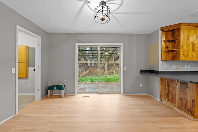 laundry room with washing machine and clothes dryer, cabinets, and light wood-type flooring