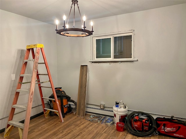 interior space with an inviting chandelier, wood-type flooring, and a baseboard radiator