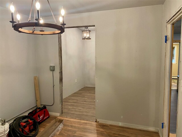 hallway with a notable chandelier and hardwood / wood-style flooring