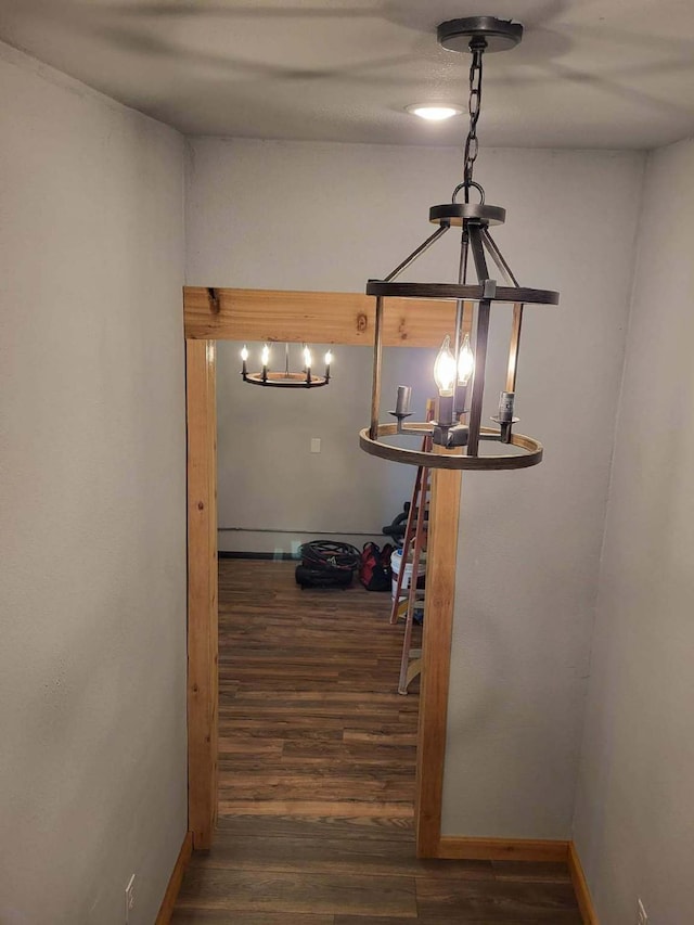 hallway featuring an inviting chandelier and dark hardwood / wood-style flooring