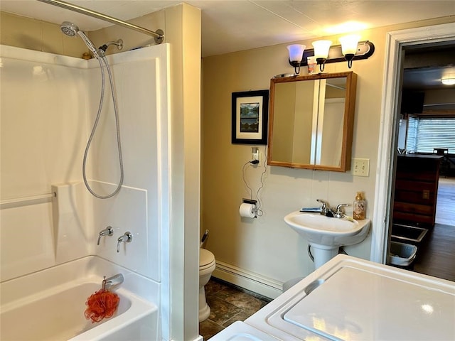 full bathroom with bathtub / shower combination, a baseboard heating unit, washer / clothes dryer, sink, and toilet