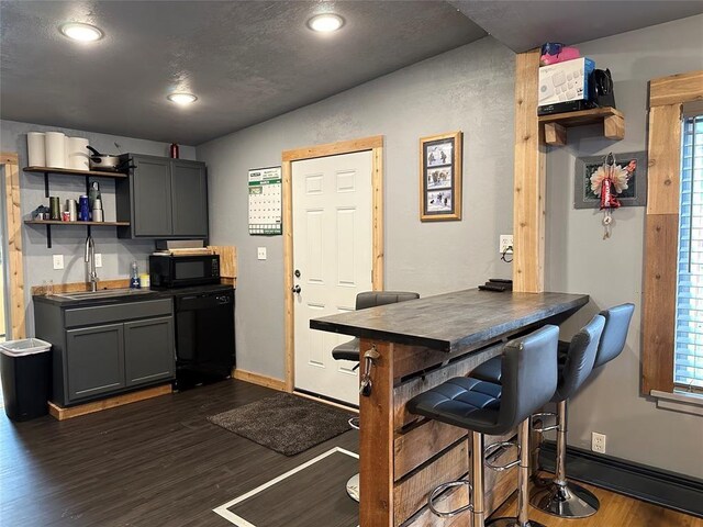 kitchen featuring a wealth of natural light, black appliances, vaulted ceiling, and sink