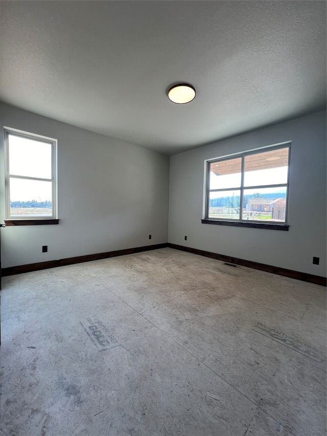 unfurnished room with a textured ceiling