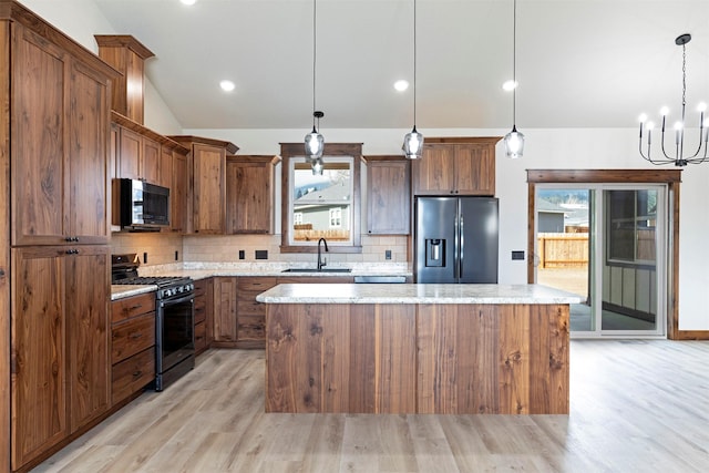 kitchen featuring stainless steel appliances, a sink, vaulted ceiling, a center island, and tasteful backsplash