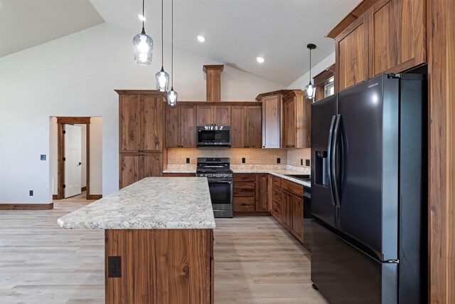 kitchen featuring stainless steel appliances, a center island, light countertops, and light wood finished floors