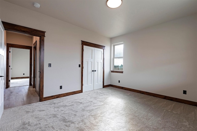 unfurnished bedroom featuring carpet floors, a closet, and baseboards