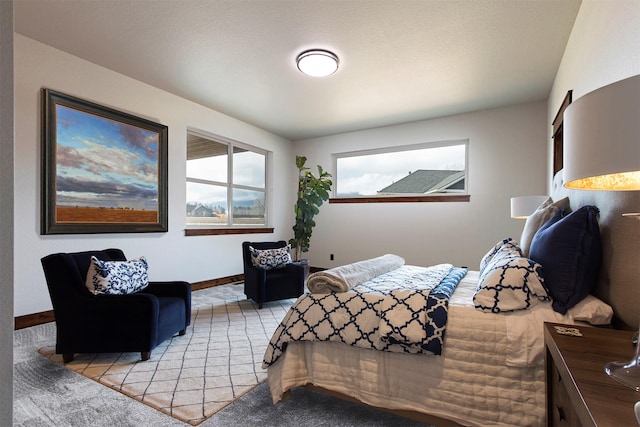 bedroom featuring light carpet and baseboards