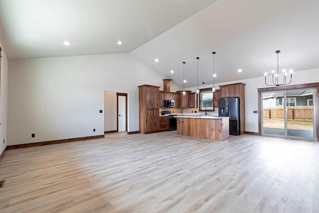 kitchen with range with gas cooktop, a notable chandelier, fridge with ice dispenser, and open floor plan