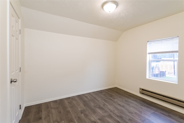 unfurnished room featuring a baseboard heating unit, vaulted ceiling, and dark hardwood / wood-style flooring