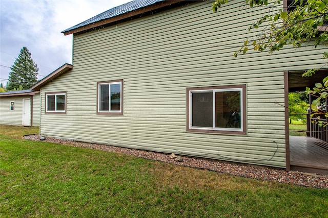 view of home's exterior with a lawn and a wooden deck