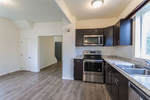 kitchen featuring plenty of natural light, stainless steel appliances, sink, and light hardwood / wood-style flooring