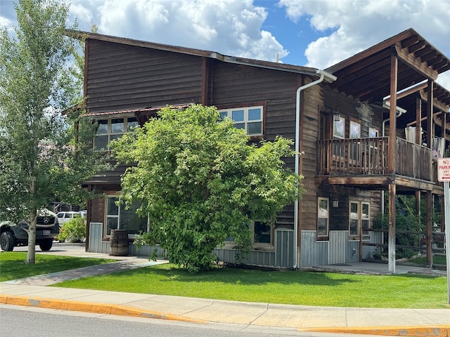 exterior space with a balcony and a lawn