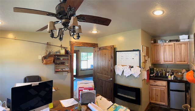 kitchen with a textured ceiling, ceiling fan, and stainless steel fridge