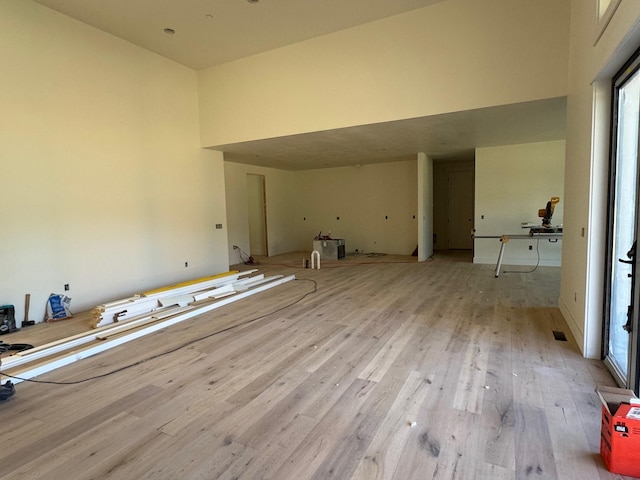 spare room with wood finished floors and a towering ceiling