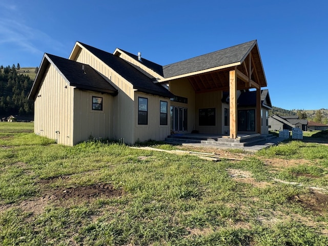 rear view of property featuring a lawn