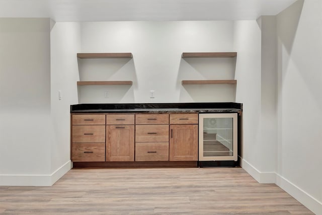 bar featuring light hardwood / wood-style floors and beverage cooler