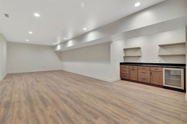 bar featuring beverage cooler and light hardwood / wood-style floors