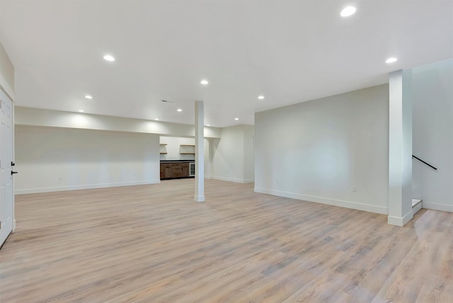 basement with light hardwood / wood-style flooring