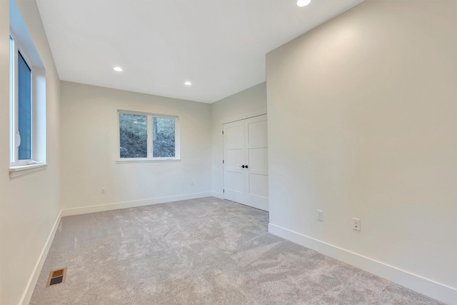 unfurnished bedroom featuring multiple windows and light colored carpet