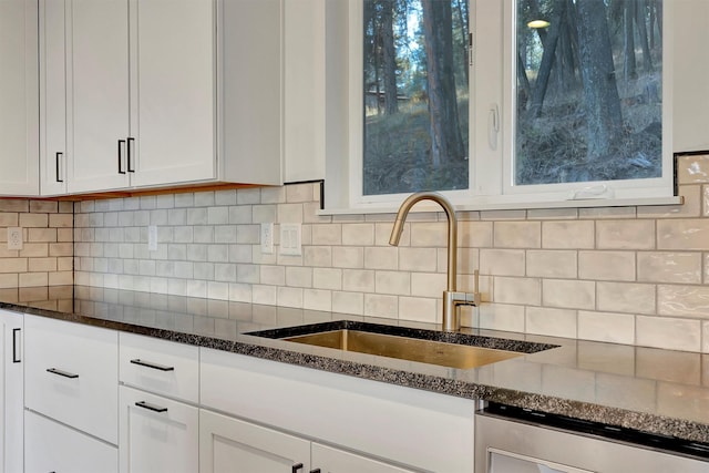 kitchen featuring sink, dishwasher, dark stone counters, decorative backsplash, and white cabinets