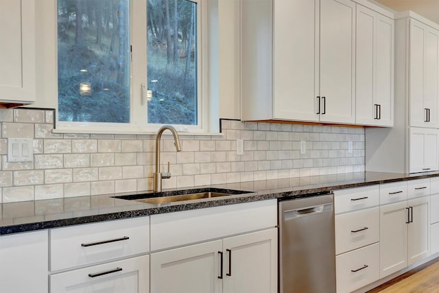 kitchen featuring white cabinetry, dark stone counters, dishwasher, and sink