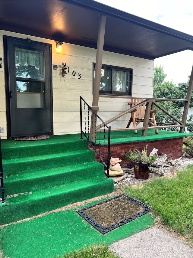 view of exterior entry with a porch