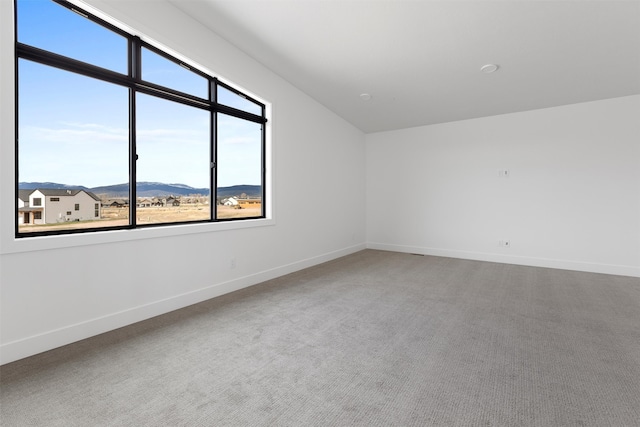 unfurnished room featuring carpet flooring and a mountain view