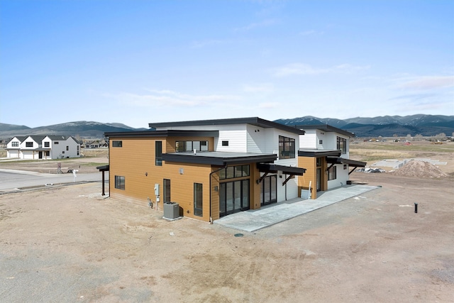 rear view of property featuring a mountain view and central AC