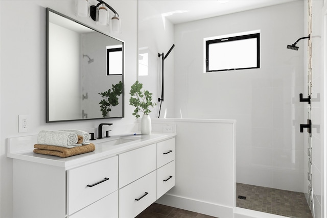 bathroom featuring a wealth of natural light, vanity, and tiled shower