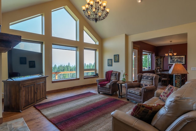 living room featuring high vaulted ceiling, light hardwood / wood-style floors, plenty of natural light, and a chandelier