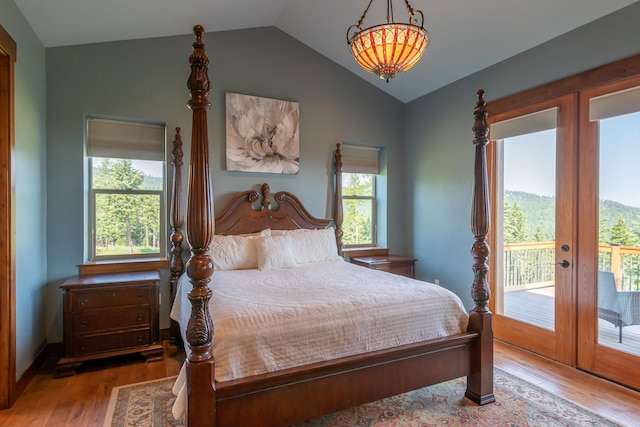 bedroom with lofted ceiling, light wood-type flooring, multiple windows, and access to outside