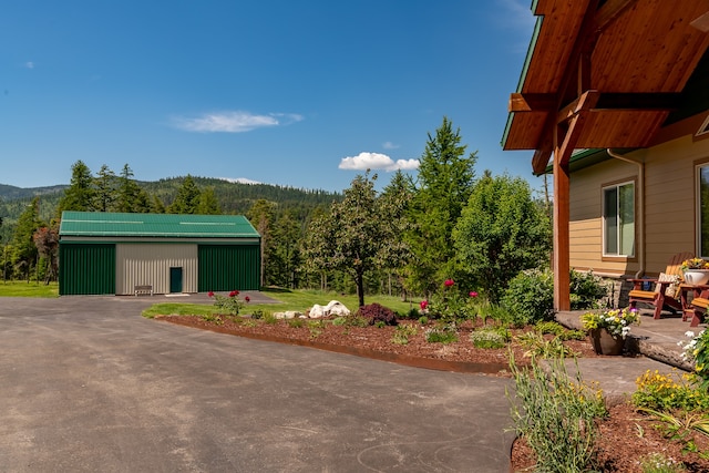 exterior space featuring a patio, an outdoor structure, and a mountain view