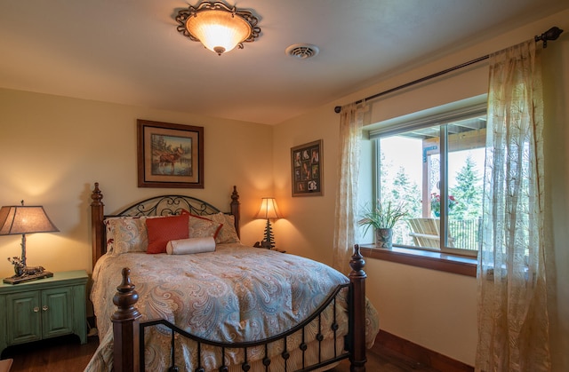 bedroom with dark hardwood / wood-style floors