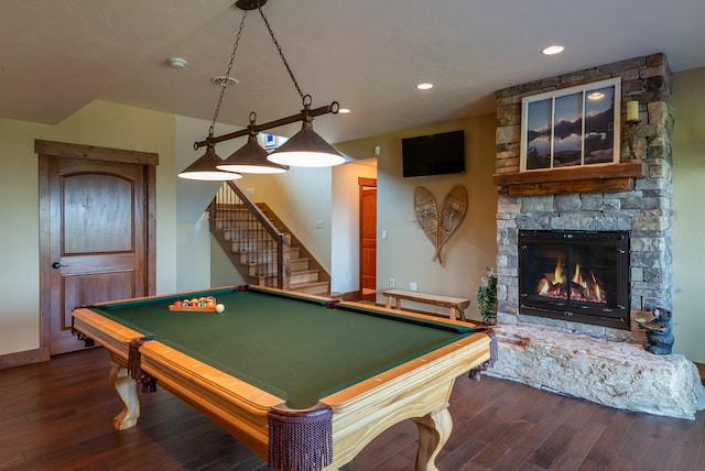 game room featuring dark wood-type flooring, pool table, and a stone fireplace