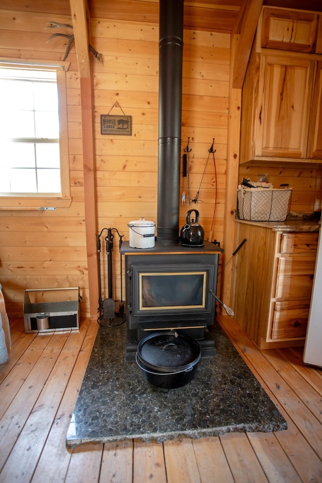 interior details featuring hardwood / wood-style floors, a wood stove, and wooden walls