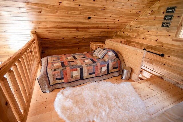 unfurnished bedroom with wooden ceiling, lofted ceiling, wood walls, and light hardwood / wood-style floors