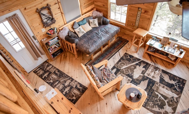 living room with hardwood / wood-style flooring, a healthy amount of sunlight, and wood walls