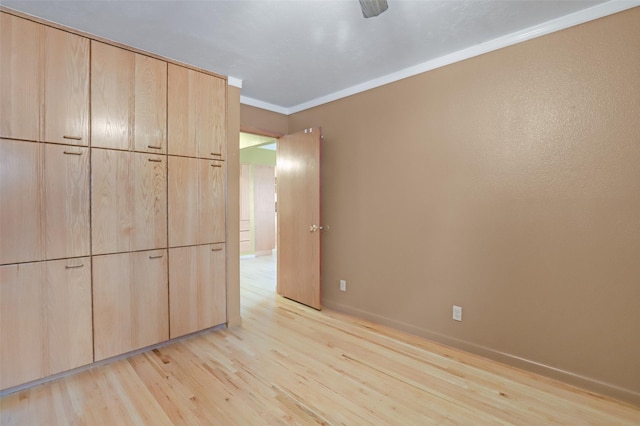 unfurnished bedroom featuring crown molding, ceiling fan, and light wood-type flooring