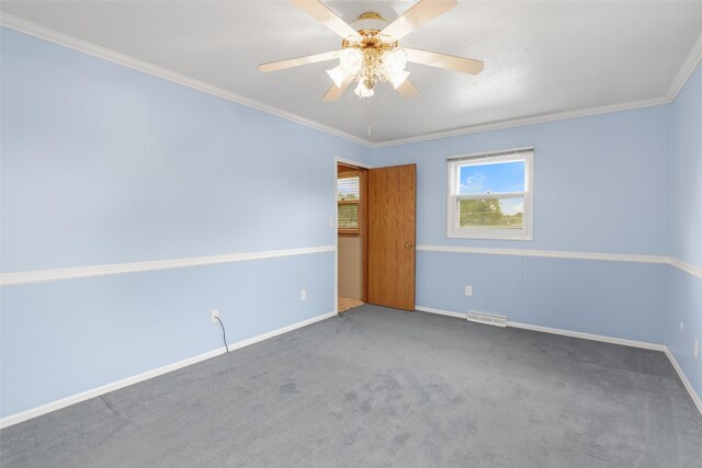 unfurnished room with ceiling fan, ornamental molding, and carpet flooring