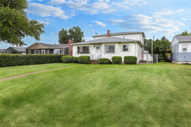 rear view of property featuring a lawn