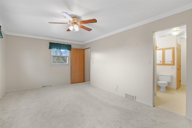 unfurnished bedroom featuring crown molding, carpet flooring, ensuite bathroom, and ceiling fan