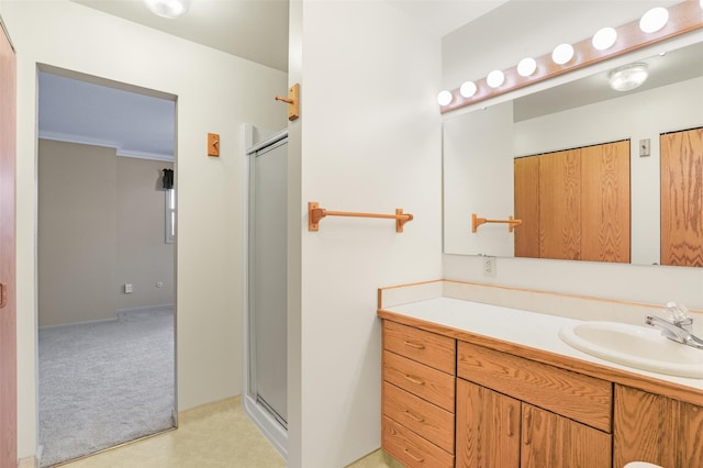 bathroom with vanity, ornamental molding, and walk in shower