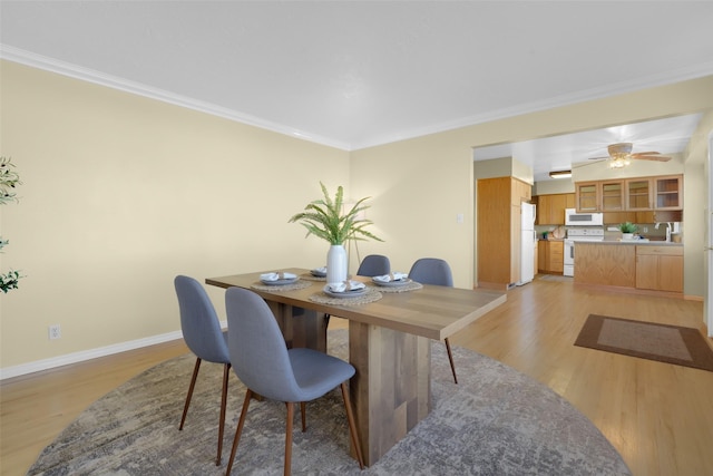 dining space featuring ornamental molding and light wood-type flooring