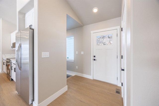 entrance foyer featuring light hardwood / wood-style floors and vaulted ceiling